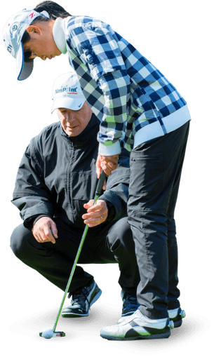 Mark Sweeney teaching a student on the green